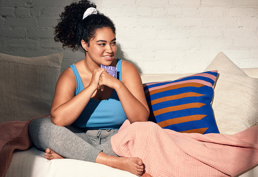 A person sitting on a comfy couch holding a Lola product